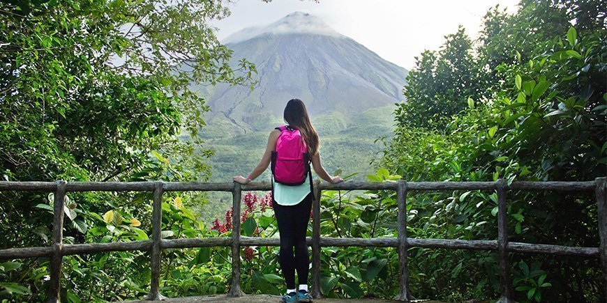 Ung kvinde kigger på Arenal-vulkanen i Costa Rica