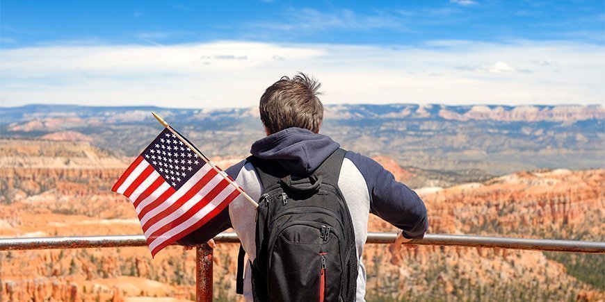 Mand har et amerikansk flag i rygsækken, mens han beundrer Bryce Canyon i Utah