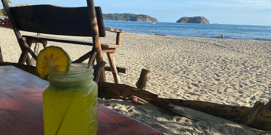 Nyder en drink på stranden Sámara i Costa Rica