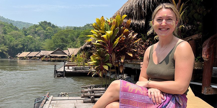 Cecilie fra TourCompass på en bænk ved River Kwai
