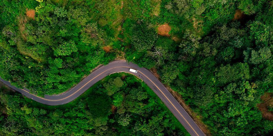 Bil set oppefra, der kører på snoet vej i Costa Rica
