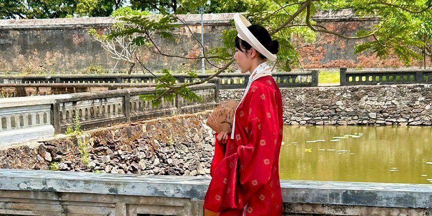 Kvinde klædt i smukt tøj i Kejserbyen i Hué, Vietnam