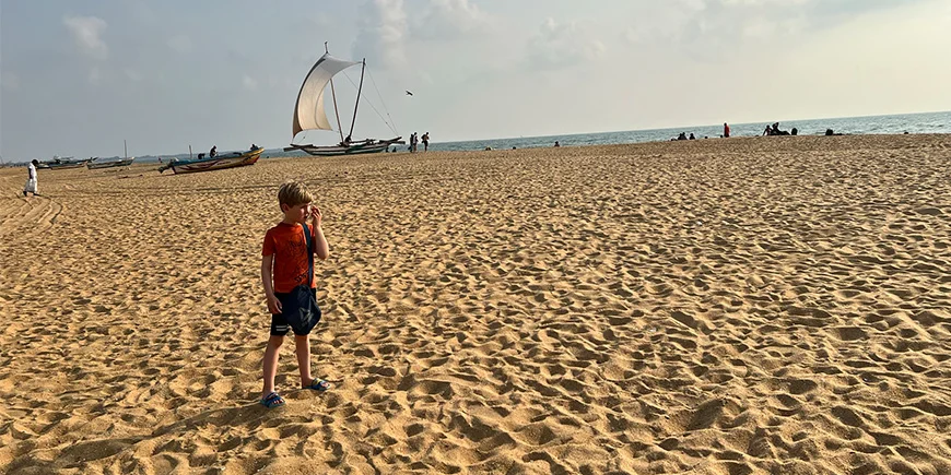 Dreng står på Negombo Beach i Sri Lanka