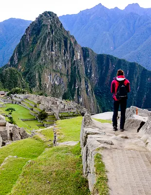 Turist ved Machu Picchu-inka-ruinen ved solopgang
